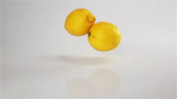 citrons tombent à la surface mouillée blanche 