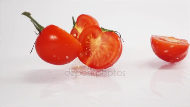 Pocos tomates en rodajas rompiendo en la superficie blanca — Vídeo de stock