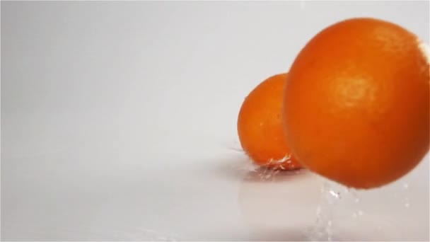 Oranges tombant et rebondissant sur la surface humide grise 