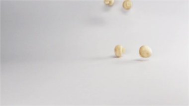 Düşen ve beyaz yüzey üzerinde zıplayan birkaç taze mantar