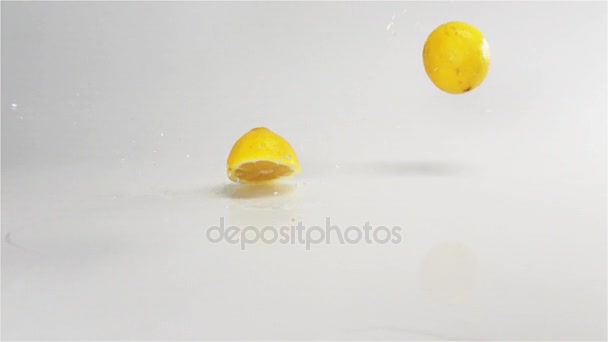 Limones caen en la superficie húmeda blanca — Vídeos de Stock