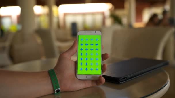 Человек рука держит зеленый экран мобильного телефона вертикальный — стоковое видео