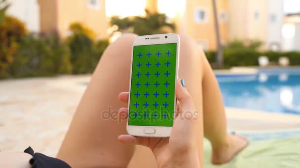 Mujer relajarse onlounger en la piscina con el uso móvil — Vídeo de stock