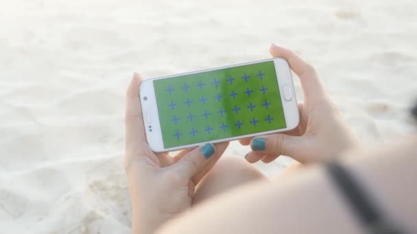 Man handen håller vit mobil horisontell på stranden — Stockvideo