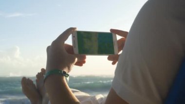 Şezlong üzerinde oturan cep telefonu tutan işadamı