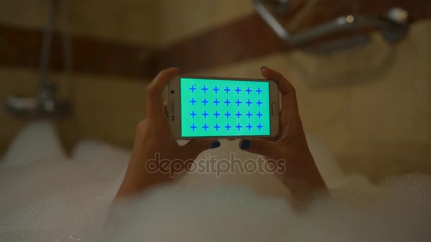 Chica utilizar el teléfono móvil en baño de espuma horizontal — Vídeo de stock