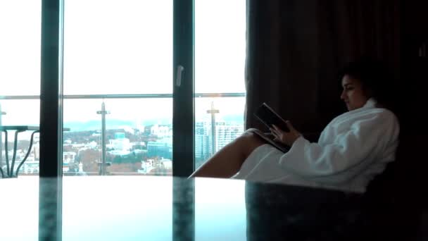 Жінка в одязі, готель сидить і читає книгу — стокове відео