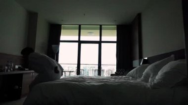 Mutlu genç adam atlamak bornoz Otel'de yatakta