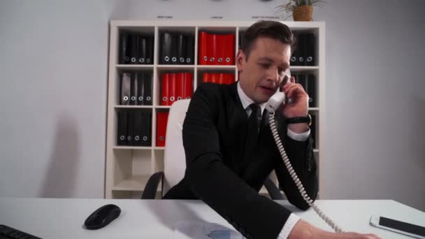 Schöner Geschäftsmann fragen Sie warten und präzise einige Ihrer Fragen per Telefon — Stockvideo