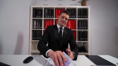 Genç yakışıklı iş adamı siyah takım elbise ve kravat euro sayma