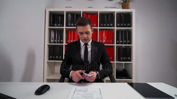 Νέοι επαγγελματίες όμορφος άνθρωπος σε μαύρο κοστούμι και γραβάτα καταμέτρηση ευρώ — Αρχείο Βίντεο