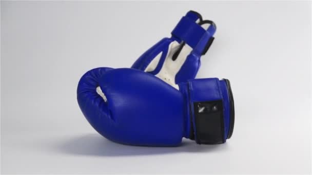 Vintage dunkelblaue Boxhandschuhe fallen auf weiße Oberfläche — Stockvideo