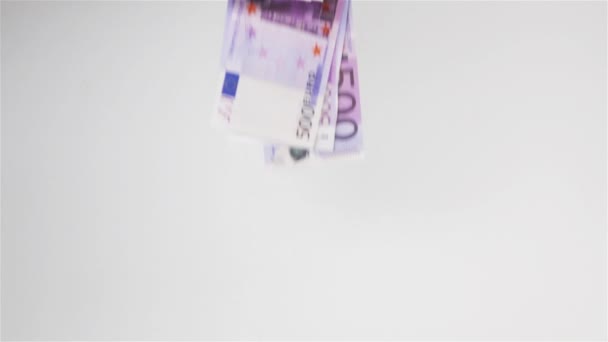 Eurogeld fliegt in die Luft und landet auf weißer Fläche — Stockvideo