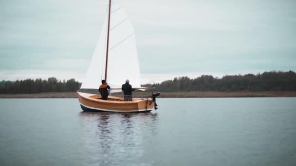 Velero de madera con dos hombres tratando de establecer el mástil — Vídeo de stock