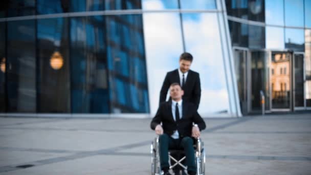 Handicap biznesmen z kolega w tle w biurze creative — Wideo stockowe