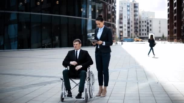 Αφεντικό σε έγκυρη αναπηρικής πολυθρόνας και του employe με το Ipad — Αρχείο Βίντεο