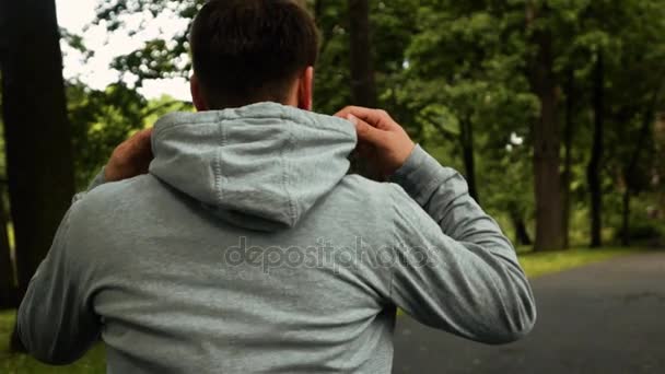 Corredor deportista poner en gancho mientras se ejecuta en el parque — Vídeo de stock