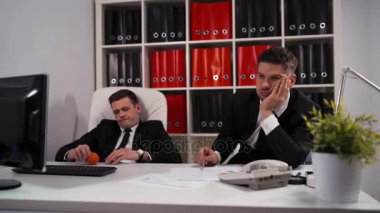 İki bilgisayar masaüstü ile iş yerinde tabloda küçük top oynamaya çalışan sıkılmış.