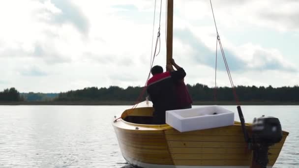 Maestro y su asistente trabajan en velero de madera en el río — Vídeo de stock