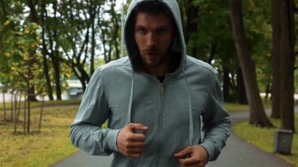 Боєць біжить в парку і бренді рук, як бокс — стокове відео