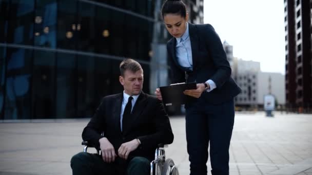 Genç sakat iş meslektaşı hakkında belgeler textpad ile iletişim kurmak için kullandığı adam tekerlekli sandalyeye mahkum — Stok video