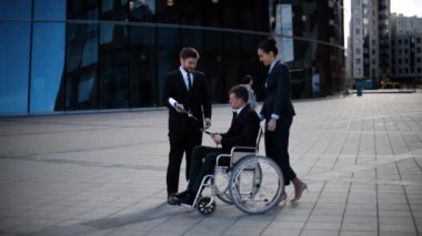 İş adamı kadın Yöneticisi ve ortağı ile toplantı sırasında tekerlekli sandalye üzerinde