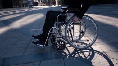 Mutlu bir gülümseme ile kamera etrafında dönen tekerlekli sandalye ile işadamı