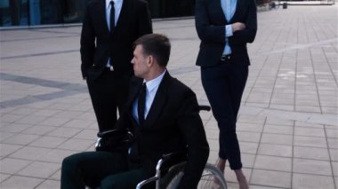 Engelli erkek tekerlekli sandalye üzerinde arkadaşları ile oturan epik çekim