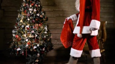 Noel Baba Noel ağacının yanında bir çanta hediye tam oturan