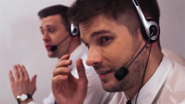 Dwóch biznesmenów z zestawów słuchawkowych, mówienie na głos wywołanie centrum pomocy technicznej — Wideo stockowe