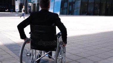 Özürlü adam tekerlekli sandalyede hareket modern iş merkezine yakın