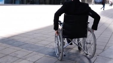 Tekerlekli sandalyede geçersiz işadamı modern iş merkezine yakın hareket