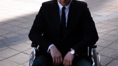 Açık tekerlekli sandalyede ciddi beyaz işadamı epik çekim
