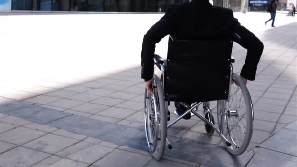 車椅子で無効なビジネスマンがモダンなビジネス センターの近くに移動します。 — ストック動画