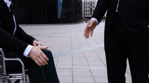 Gärna entreprenör skakar hand med ogiltig affärsman utomhus — Stockvideo
