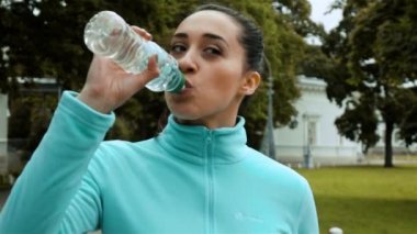 Kadın atlet bir şişe su içer