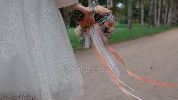 Mireasa cu un frumos buchet de flori de mers pe jos în parc — Videoclip de stoc