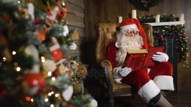 Noel Baba eski kırmızı ipek albümde yakın oyuncak ve ışıklar ile Noel ağacı ortaya çıkarır