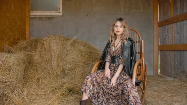 Jeune femme se balançant dans un fauteuil à bascule sur un ranch . — Video