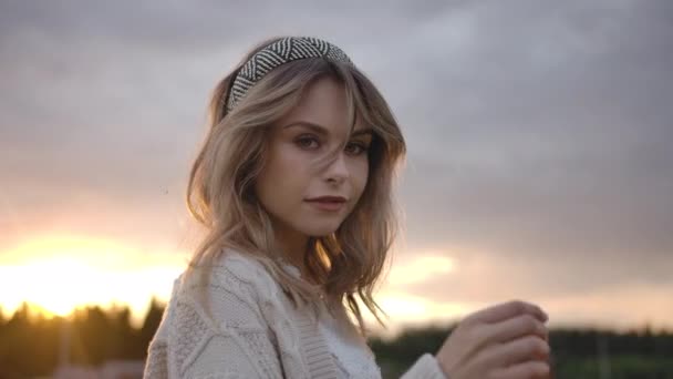 Mujer romántica en el campo girando alrededor y tocando el cabello durante la puesta del sol — Vídeo de stock