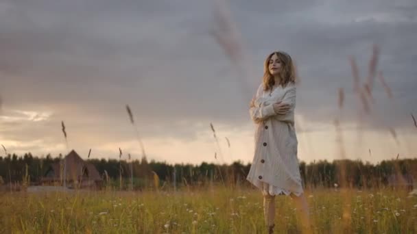 Чуттєва жінка ходить у полі зі складеними руками — стокове відео