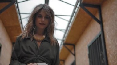 Ahırda yürüyen şık sarışın kadın.