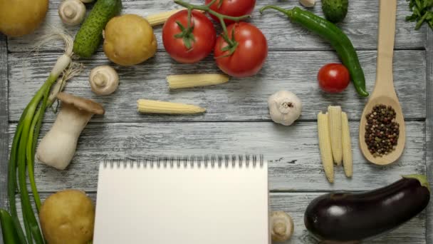 Libro de recetas arrojado sobre la mesa con verduras. Fácil de colocar Su recibo en un papel en blanco . — Vídeos de Stock