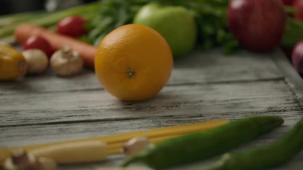 Persona de la cosecha rodando naranja en la mesa — Vídeo de stock