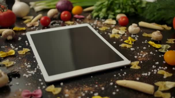 Tablet amidst pasta ingredients in kitchen — Stock Video