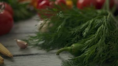 Masadaki turunçgillerin yanında olgun sebzeler ve otlar