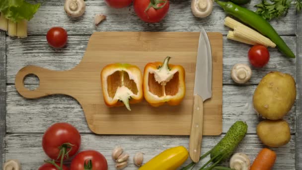 Two male hands taking halves of orange paprika from the board taking turns one by one. — Stock Video