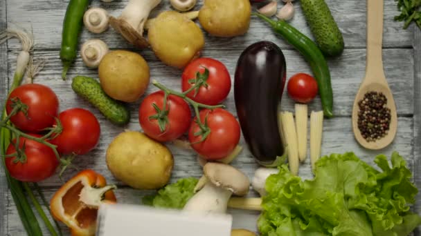 Hand throws a notepad for recipes on the table with vegetables — Stock Video