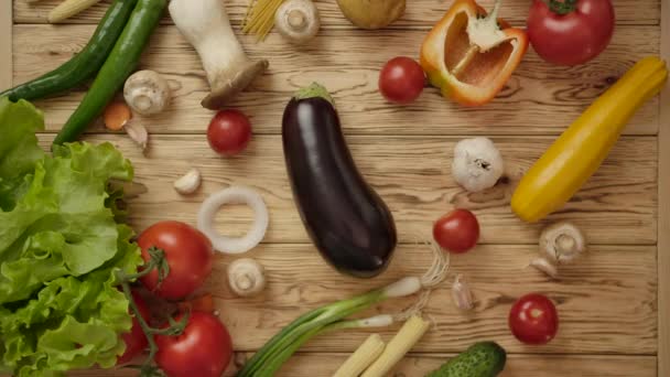 Gezichtsloze kok neemt aubergine van houten tafel. Vegetarisch voedselconcept — Stockvideo