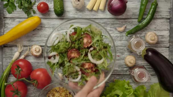 Hånd fjerner fra rammen salat af greens og tomater. – Stock-video